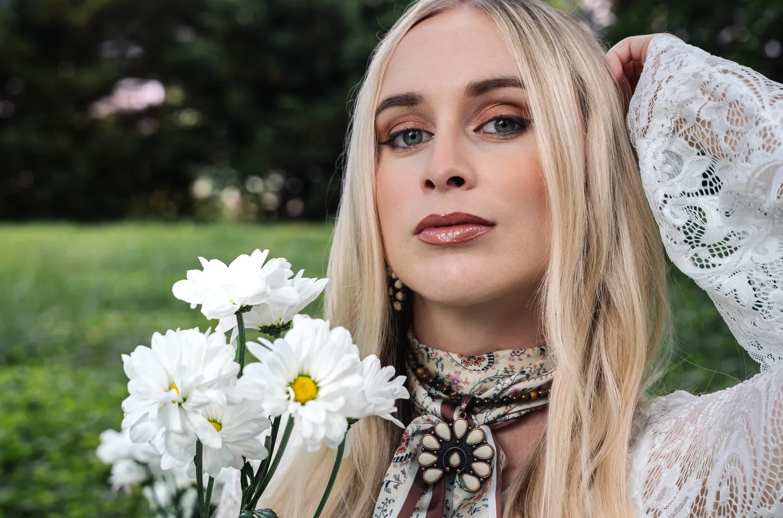 Melanie Dyer with white daisies in a green field