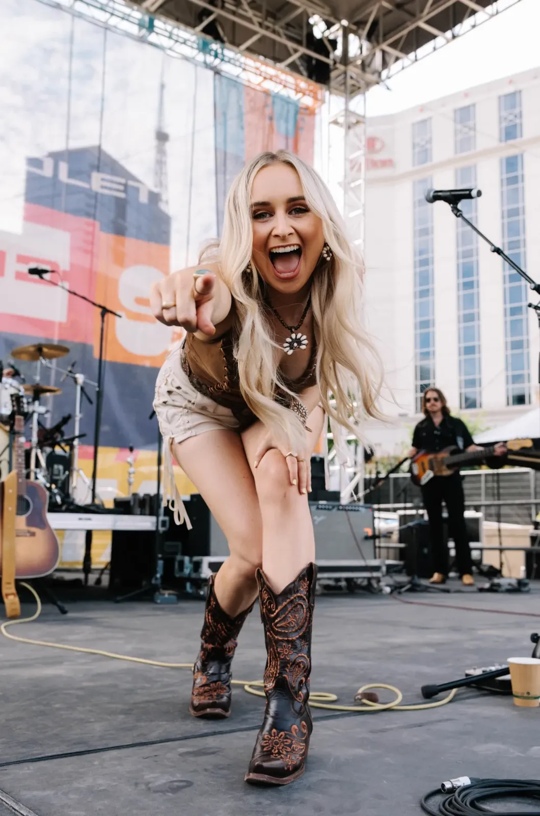 Melanie Dyer laughing and pointing at the crowd from the festival stage