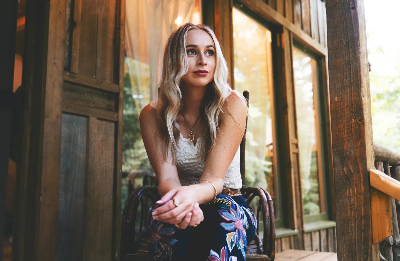 Melanie Dyer seated on a wooden cabin porch