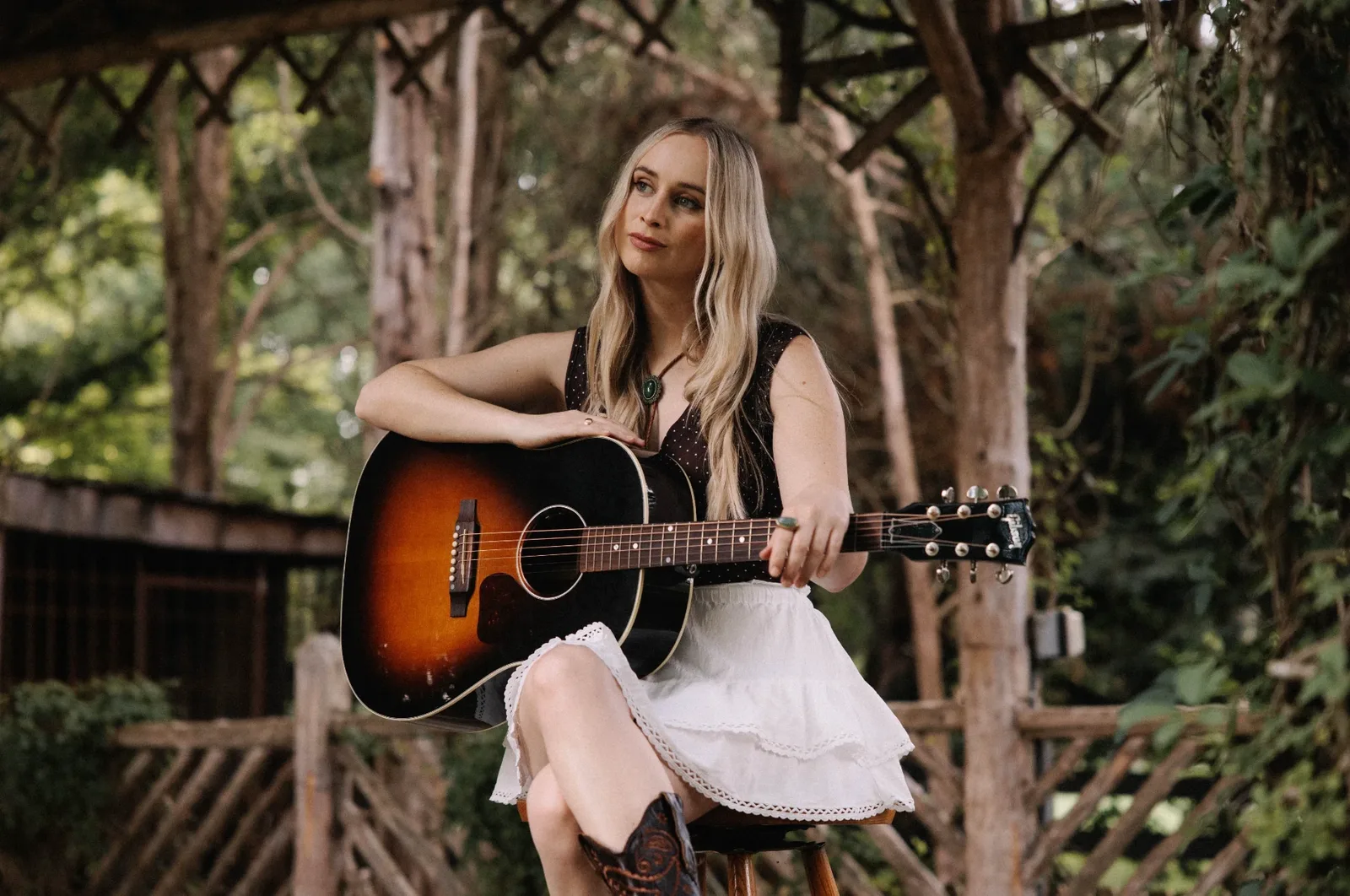 Melanie Dyer seated with her sunburst Gibson guitar